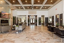 Elegant and spacious lobby featuring luxurious marble flooring, stylish seating areas, and vibrant indoor plants under a stunning wooden ceiling with decorative lighting.