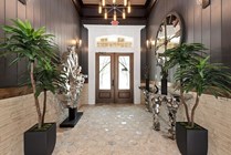 Chic entrance with modern geometric decor, lush potted plants, and unique art features, exuding elegance and style.