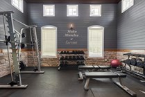 Inviting home gym with state-of-the-art equipment, sleek gray walls, and motivational decor, perfect for fitness enthusiasts.