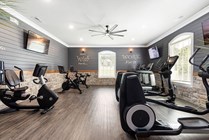 Modern fitness room with sleek exercise bikes, motivational quotes on walls, and ample natural light.