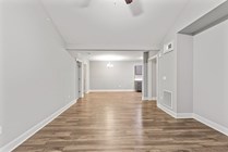 Spacious open-plan living area with sleek hardwood floors and elegant neutral tones.