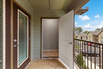 Inviting balcony entrance with a storage closet andwooden deck