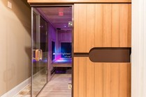 Luxurious community sauna with wood paneling and soft ambient lighting for a relaxing experience.