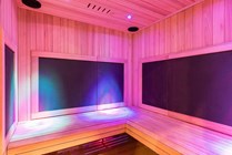 Luxurious infrared sauna with ambient LED lighting, featuring modern wood paneling and a cozy bench.
