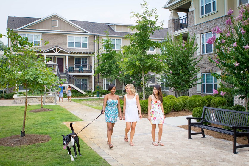 Girls walking with dogs in apartment community.