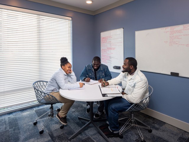 Players Club Apartment Amenities Residents studying in apartment study room